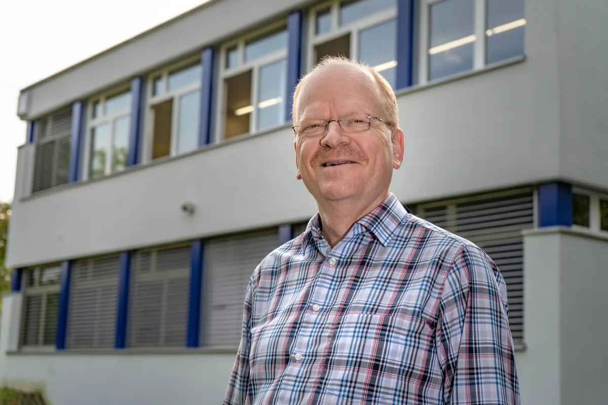 Ulrich Schmid steht vor einem Haus.